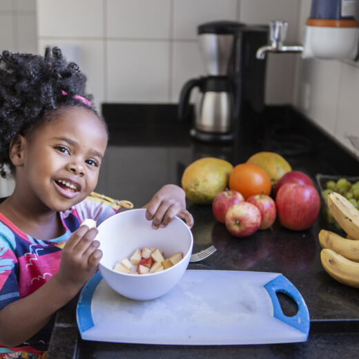 little girl with a bowl of apple slices.