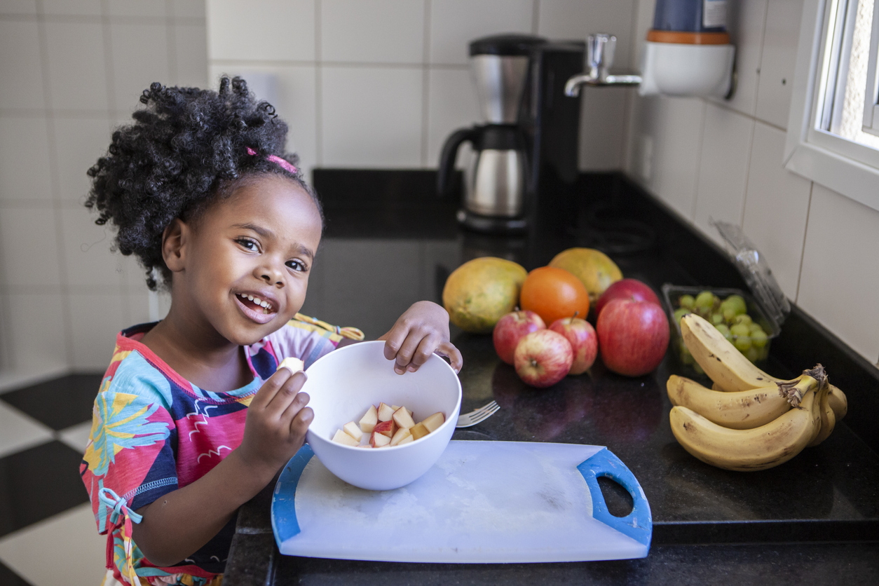 little girl with a bowl of apple slices.